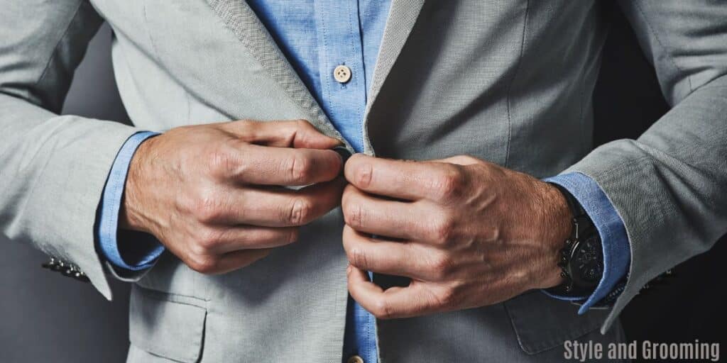 Strong Successful Male dressed for success, closing is suit jacket showing off is nice watch. 