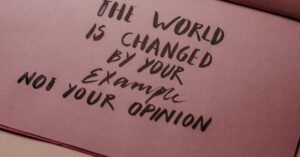Motivational phrase emphasizing actions over words displayed on textured paper.
