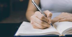 a person writing on a book